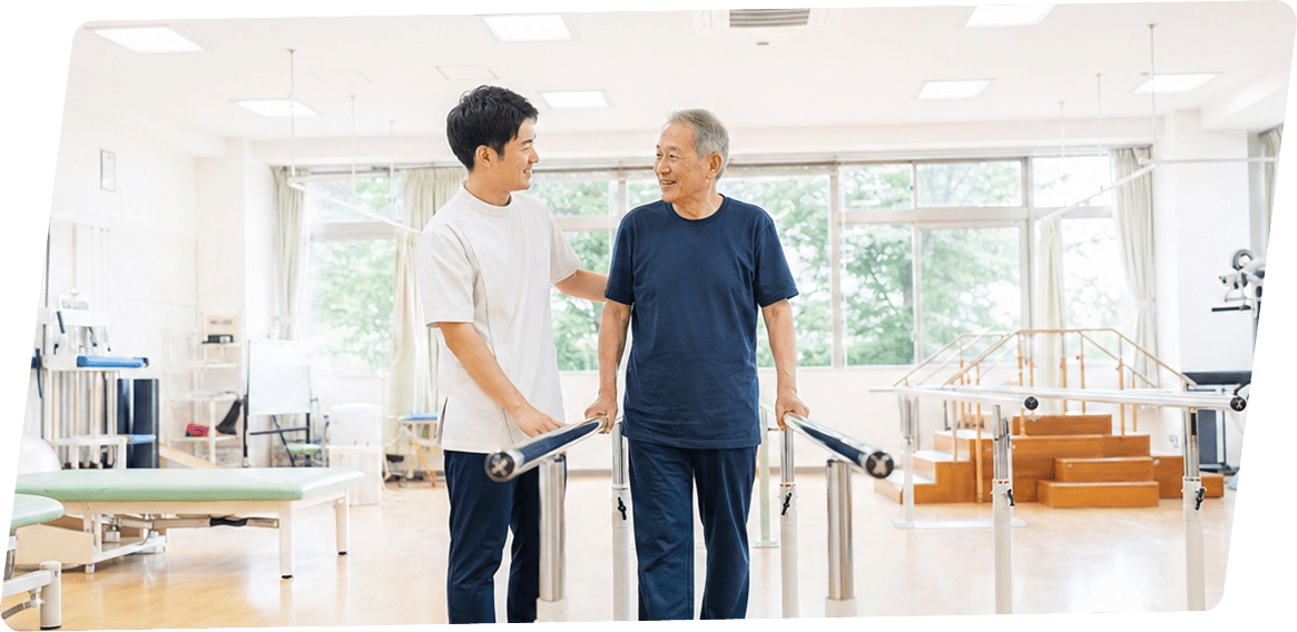 リハビリスタッフのサポートを受けながら歩行訓練をする男性