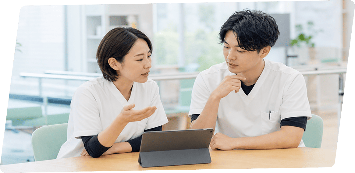 タブレットを見ながら意見を交わす医療従事者